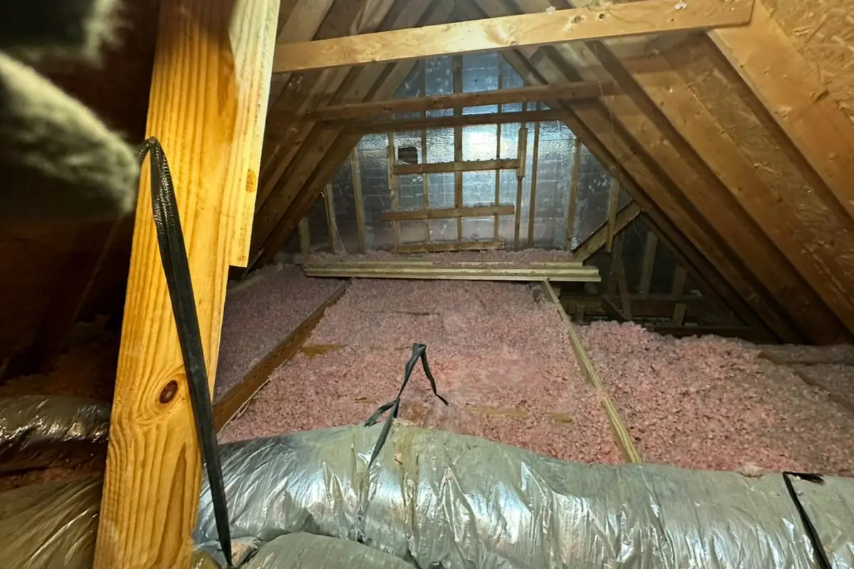 Attic before: old, patchy insulation and bare rafters