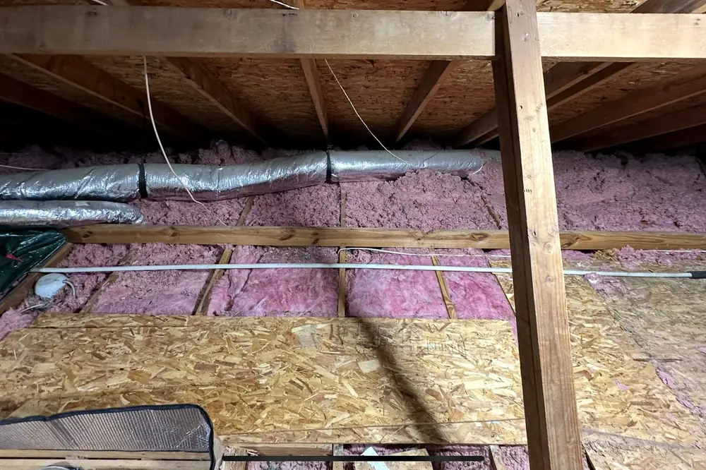 Attic before: aging insulation and open rafters